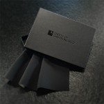 Black A6 Box with Black Sheets of San Francisco Logo and folded black fluidproof plus fabric sample spilling out of box