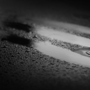 Scratch marks through water droplets on a black fluid proof sheet illustrating skin scratchers