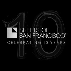 Sheets of San Francisco logo on a black backdrop with Celebrating 10 years and a large figure 10 that looks watery